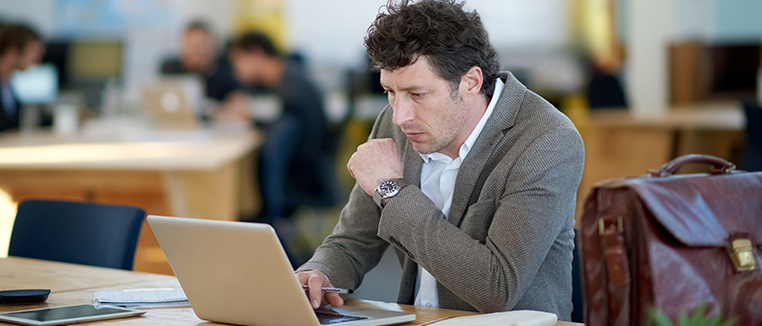A businessman working on his computer in a modern office